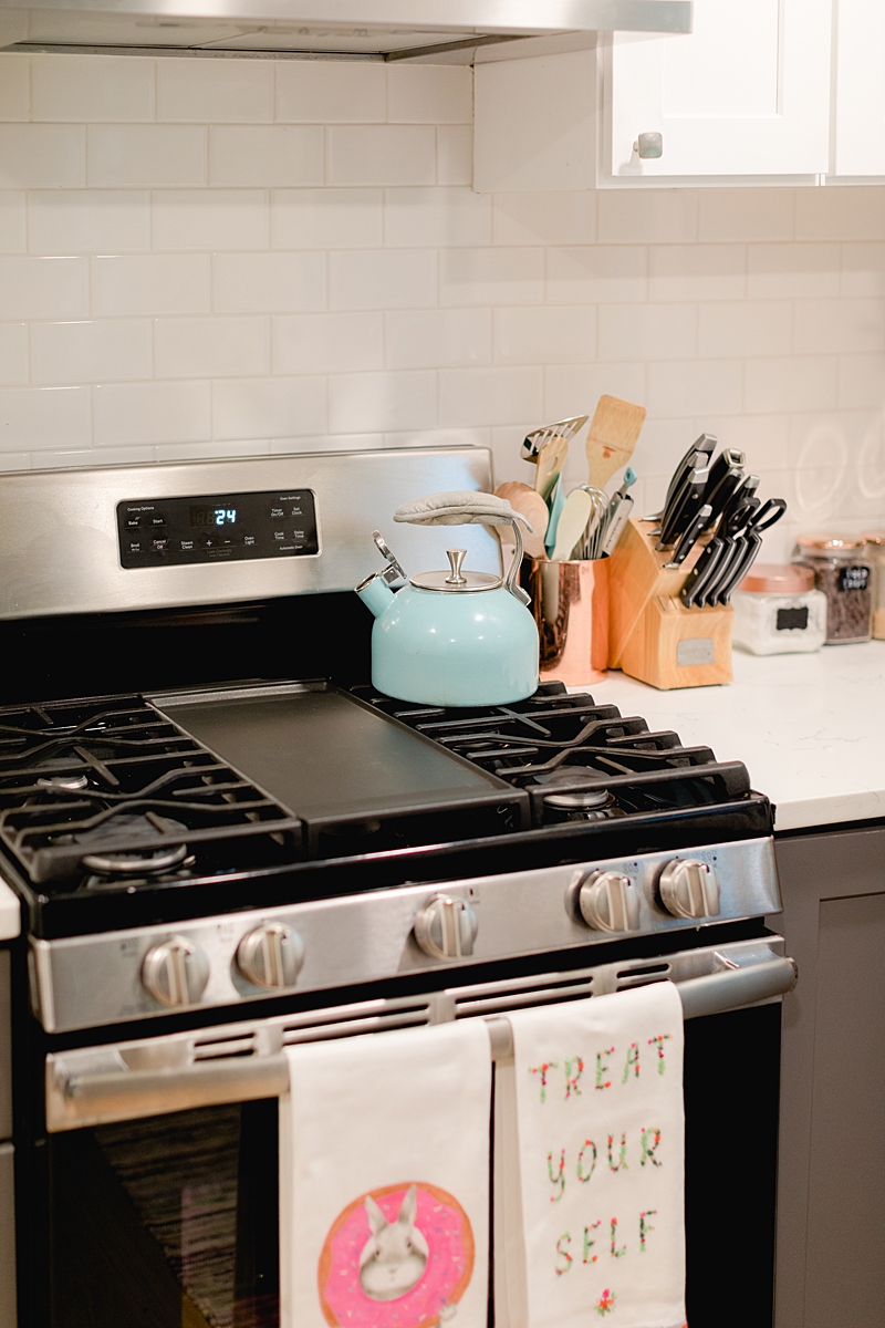 Our dreamy kitchen! Simple white subway tile backsplash, navy gray cabinets and marble counters. We're in South Austin, Texas in a neighborhood called Cherry Creek. Click through to see how we've settled so far!