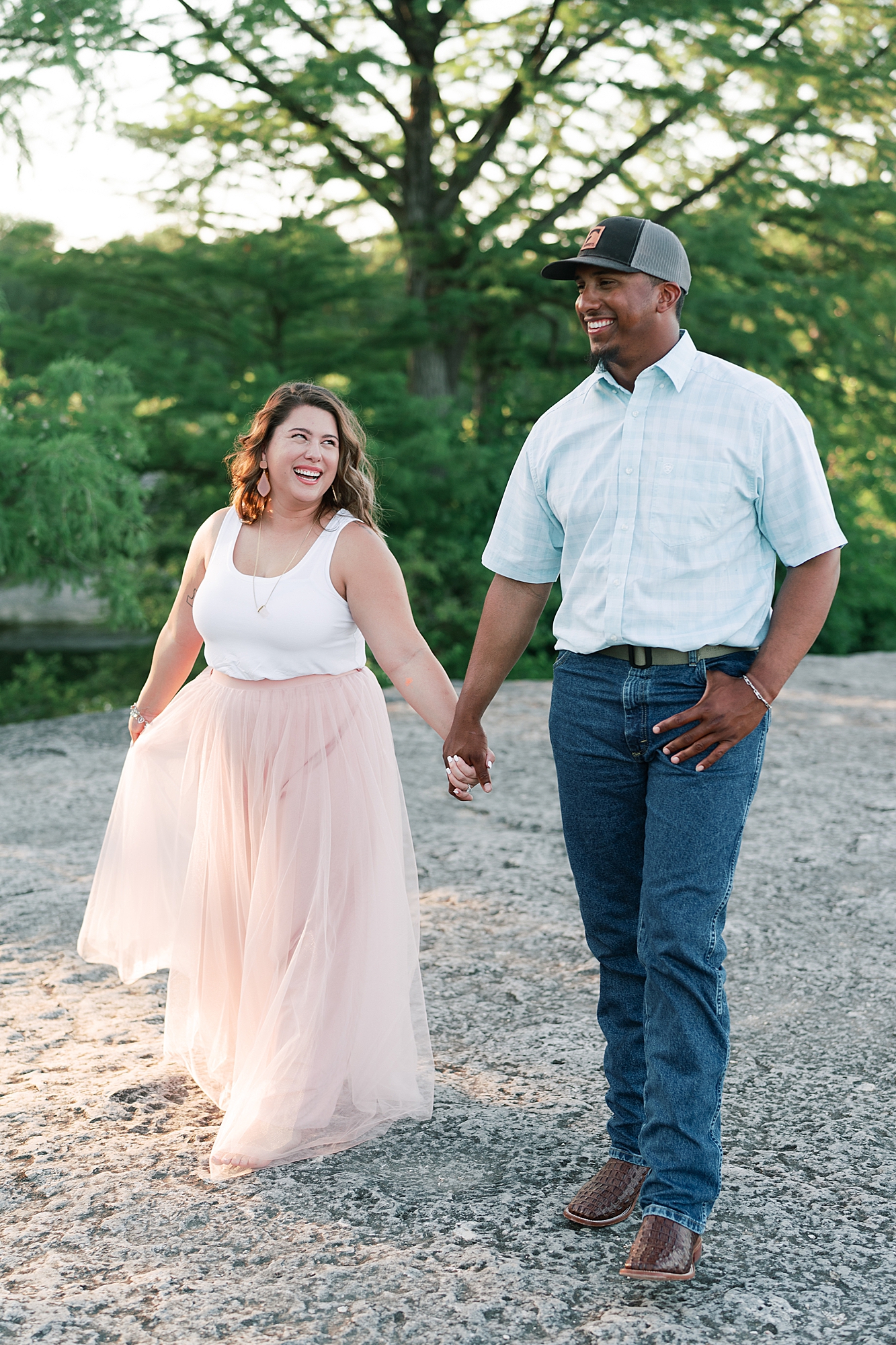 This beautiful bride to be DIY'd her own denim bridal jacket, to go with her flowy pink tulle skirt. This created the perfect outfit for her engagement session at McKinney Falls! Click through to see her outfit inspo and see how adorable she is with her fiance! #engagementsession #atxengagementsession #engagementsessionlocations #engagementsessionoutfit