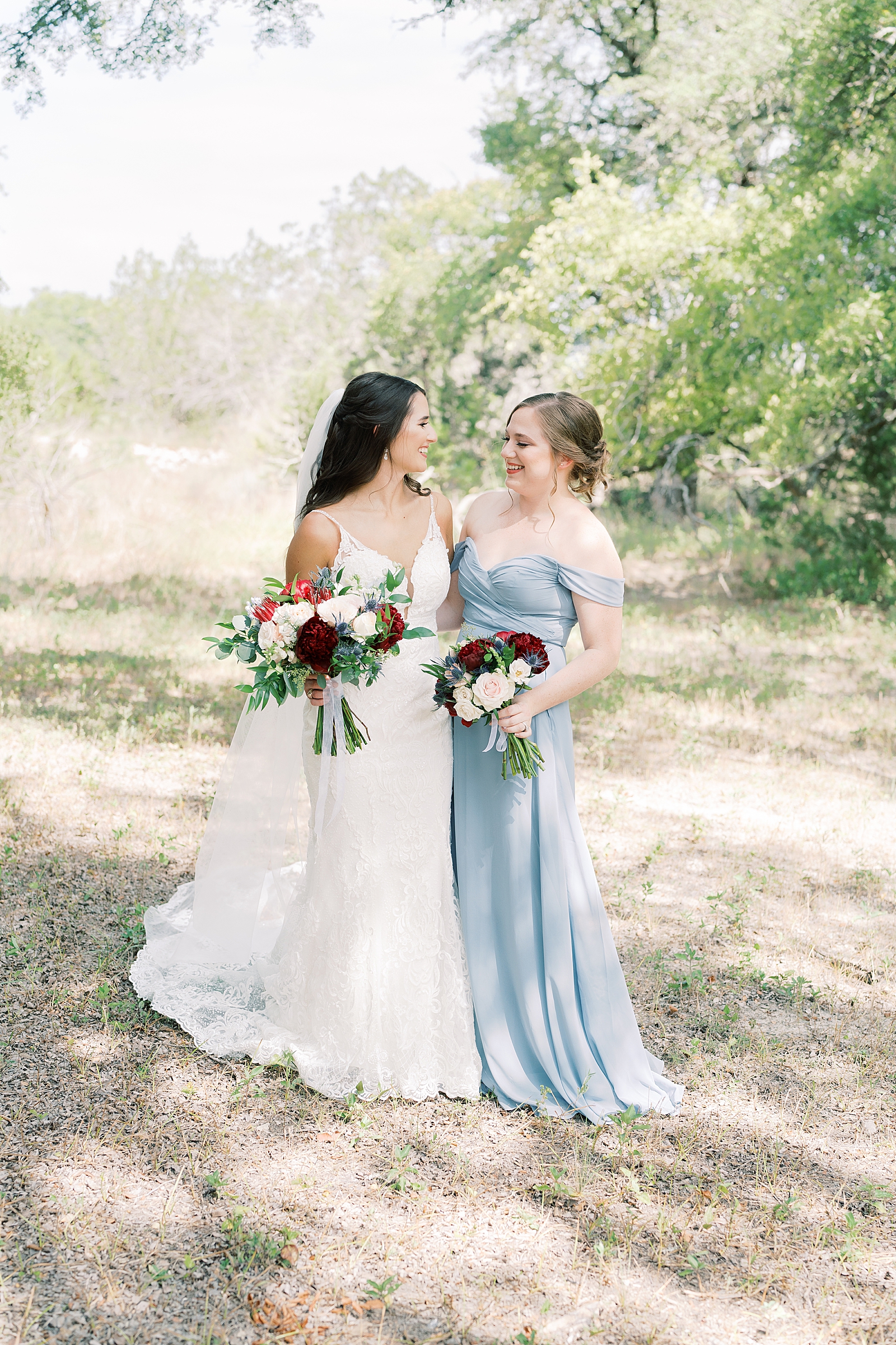 This navy, light gray, with pops of burgundy wedding day is some serious color palette inspo! In Dripping Springs, Texas at Saddle Creek Weddings, this day was full of elegance, fun and thoughtful details. Click through to see all the pretty! #weddingdayinspiration #dustybluewedding #dustybluebridesmaiddress #maidofhonor