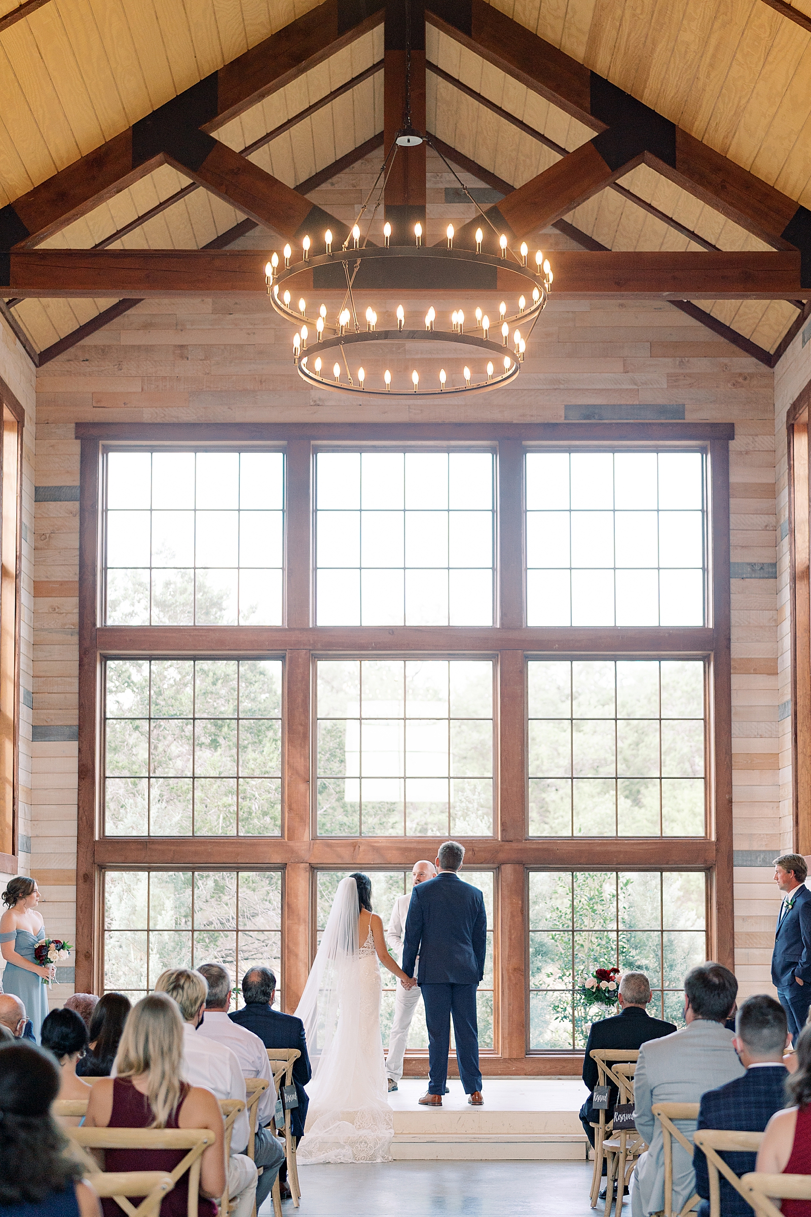 This navy, light gray, with pops of burgundy wedding day is some serious color palette inspo! In Dripping Springs, Texas at Saddle Creek Weddings, this day was full of elegance, fun and thoughtful details. Click through to see all the pretty! #weddingdayinspiration #dustybluewedding #austintexaswedding #hillcountrywedding 