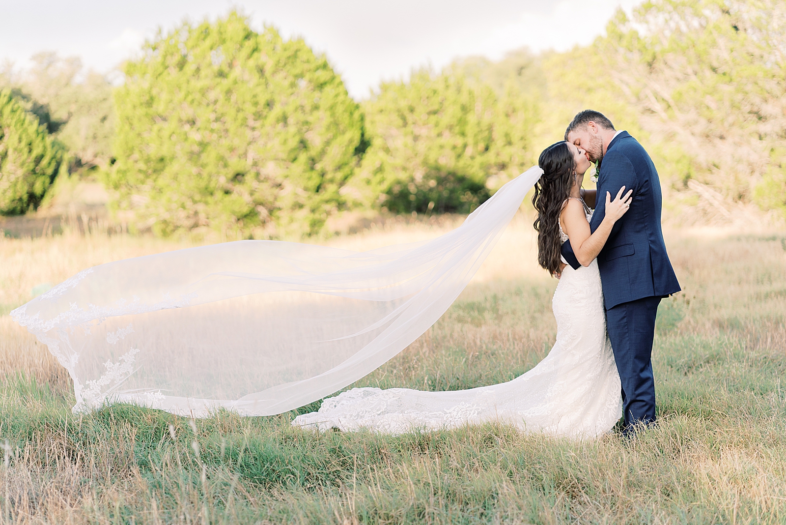 This navy, light gray, with pops of burgundy wedding day is some serious color palette inspo! In Dripping Springs, Texas at Saddle Creek Weddings, this day was full of elegance, fun and thoughtful details. Click through to see all the pretty! #weddingdayinspiration #dustybluewedding #austintexaswedding #hillcountrywedding #veiltoss 
