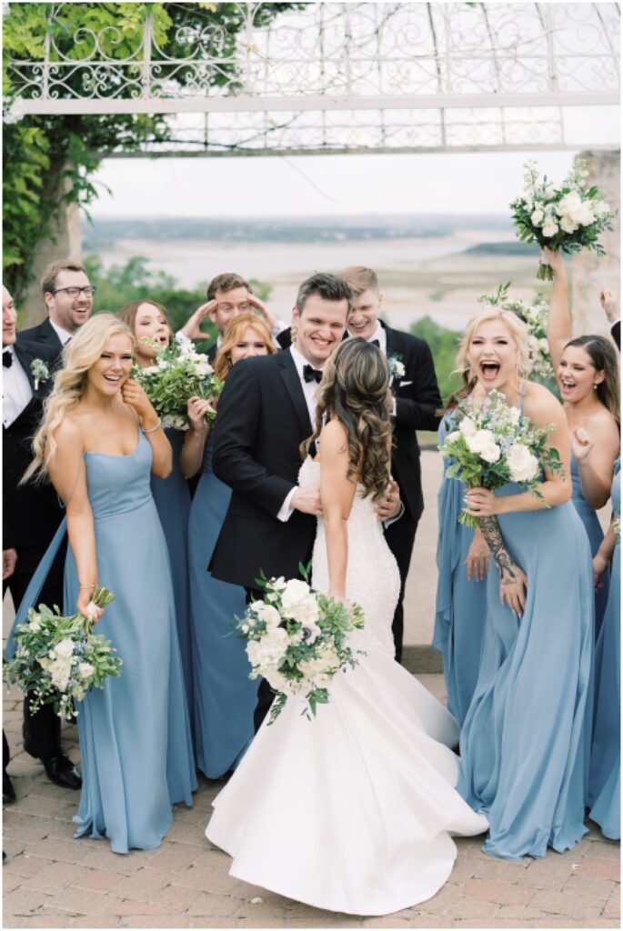 Bride and groom with their wedding party. Blue bridesmaids dresses at Vintage Villas in Austin, Texas